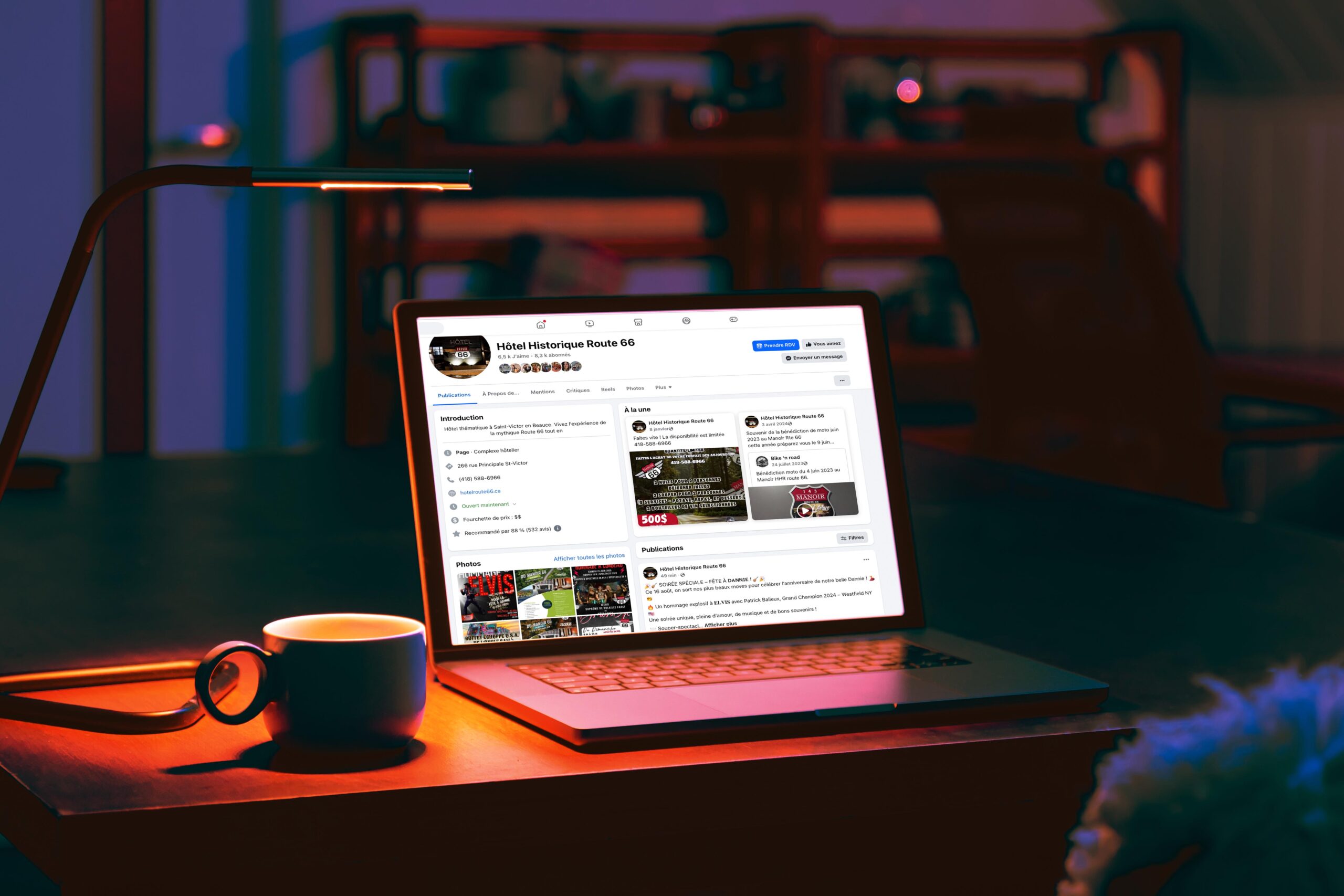 Laptop and cup on a table in a dark room with a blank screen at night.